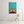 Colorful abstract painting of a silhouette against a sunset on a white wall.