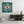 Decorative wall art of an eye with swirling patterns on a teal background, displayed in a modern living room.